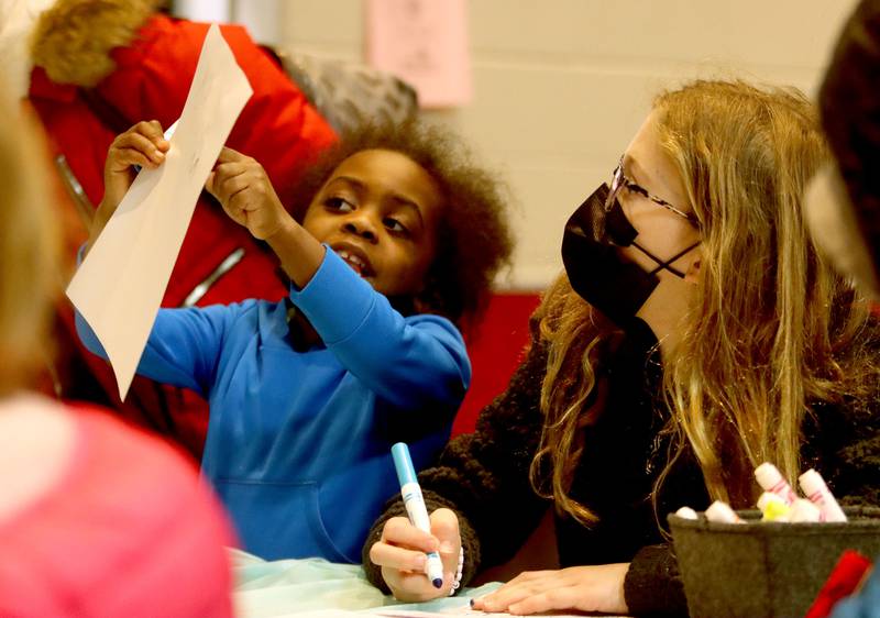 Makenzie Belin, 6, left, of Huntley, proudly shows her work to friend Jillian Rowe, 10, of Huntley. The pair are coloring pages during the Black History Month event, titled “Celebrating Black Stories: Narratives on Identity, Belonging and Community," Thursday, Feb. 24, 2022, at Huntley High School.