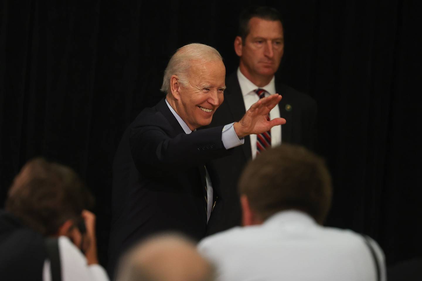President Joe Biden waves as he exits after speaking about Social Security and Medicare during a stop in Joliet at Jones Elementary School on Saturday.