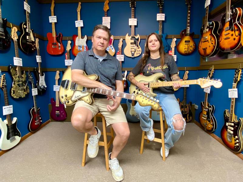 (From left) Owner Damon Henrickson and daughter and store manager Anna Henrikson pose with guitars on Saturday, Sept. 14, 2024, at Ax-In-Hand Guitars, 817 W. Lincoln Highway, Suite B, DeKalb. The guitar shop, owned and operated since 1964 by multiple generations of the Henrikson family, is celebrating 60 years in 2024.