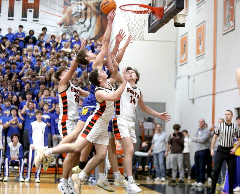 Wheaton North’s Cal MacKay gets the ball to the basket through a slew of Wheaton Warrenville South defenders during a game on Friday, Feb. 7, 2025 in Wheaton.