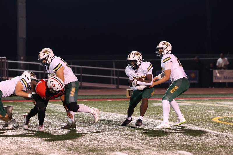 Waubonsie Valley quarterback Colin Ford hands off the ball to teammate Ishmaiah Elliott during the Warriors' 35-6 loss to Bradley-Bourbonnais on Friday, Sept. 12, 2025.