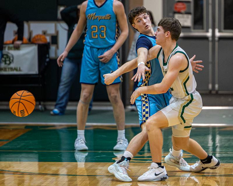 Alec Tomsha (12) of St. Bede passes ball around Easton DeBernardi (3) of Marquette as he reaches across the body of Tomsha on Friday, January 16, 2026 at St. Bede Academy in Peru.