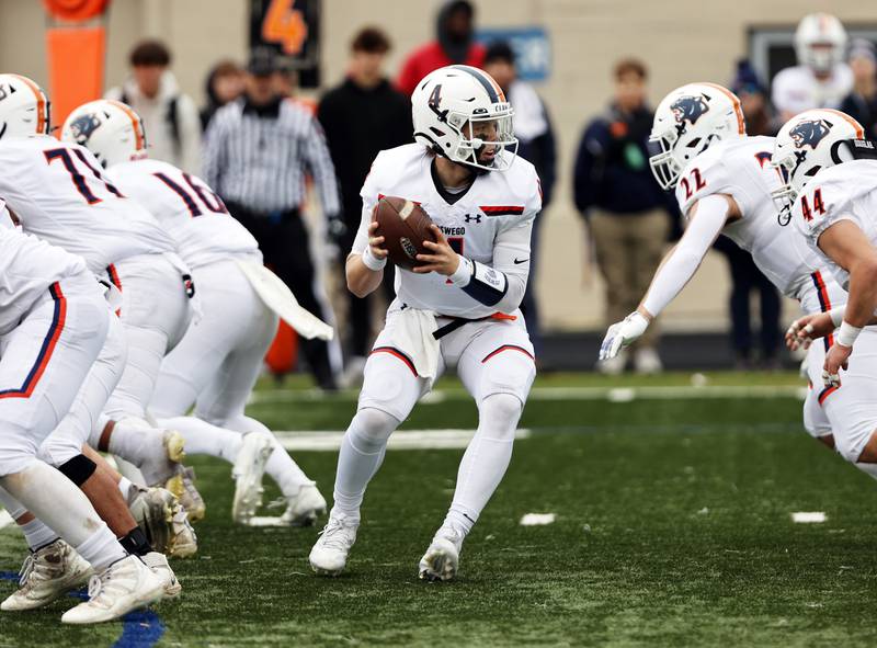 Oswego's Drew Kleinhans (4) drops back to hand off the ball during the varsity football second-round 8A playoff game between Oswego and Lane Tech on Saturday, Nov. 8, 2025 in Chicago.