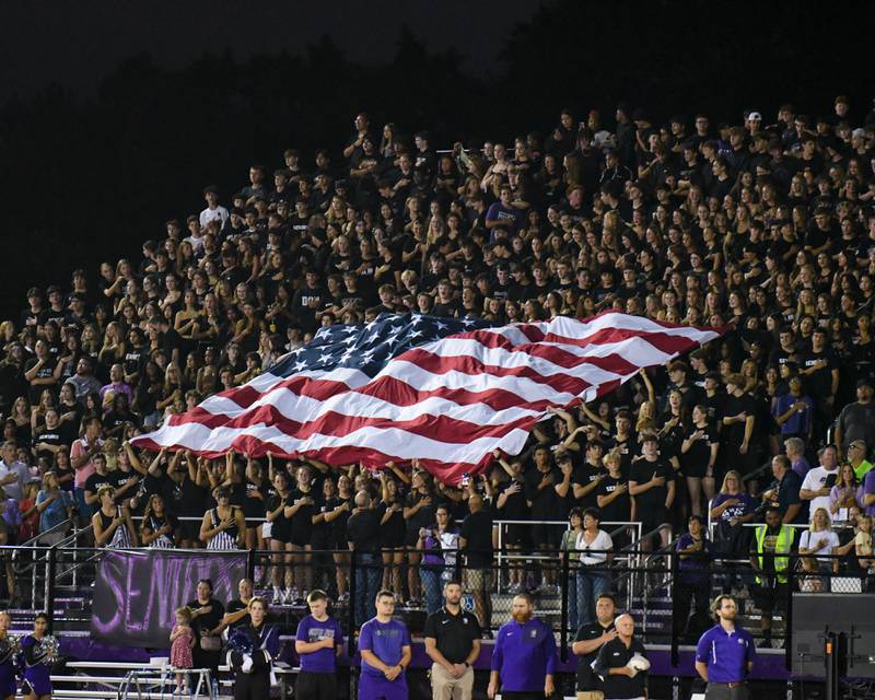 Downers Grove North’s students hold an American flag during the National Anthem on Friday Sept. 12, 2025, before the start of the game against Hinsdale central held at Downers Grove North High School.