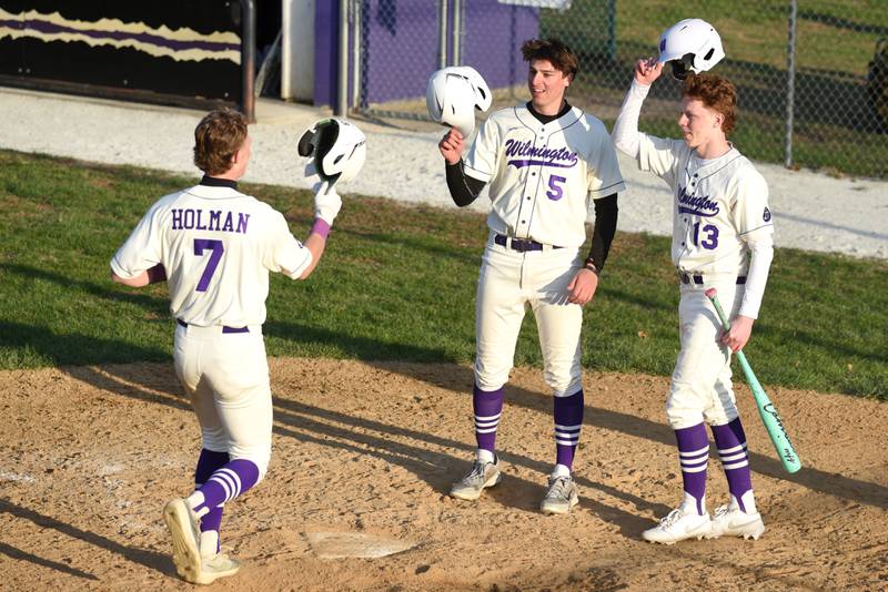 Wilmington's Evan Kuypers, center, and Dane Van Duyne, right, congratulate Cooper Holman after his grand slam during a home game against Herscher Tuesday, April 7, 2026.