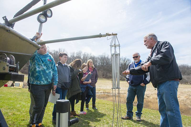 Volunteers Terry Heflin (right) and Jim Yenney talk about the mechanism used to temporarily shock the fish in order to harvest their eggs and sperm.