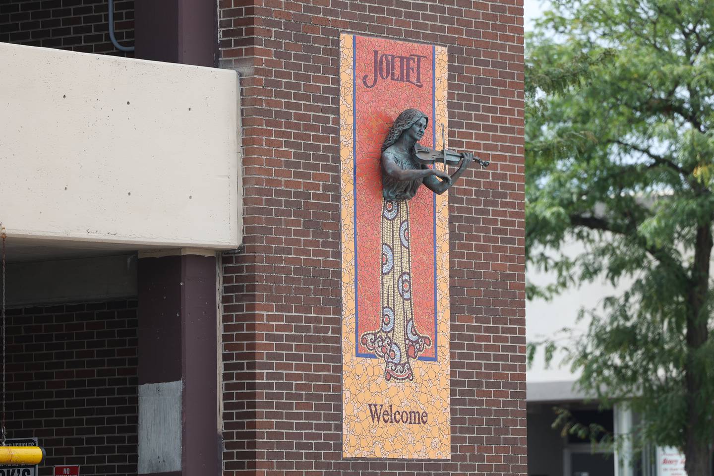 A bust of violinist Scarlet Rivera, a Joliet native, hangs on a wall of a building in Downtown Joliet on Tuesday, Aug. 8, 2023.