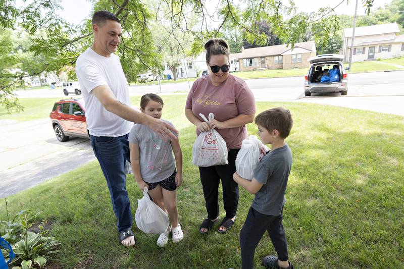 Members of the Ashlin family – Travis, Kassy, Harper, 8, and Brady, 6 – pick up lunch Wednesday, July 16, 2025, at Lincoln School in Dixon.
