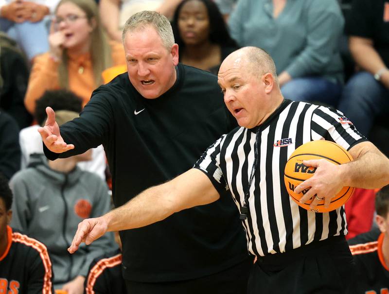 DeKalb Head Coach Mike Reynolds, has a discussion with an official during their game against Waubonsie Valley Friday, Feb. 21, 2025, at DeKalb High School.