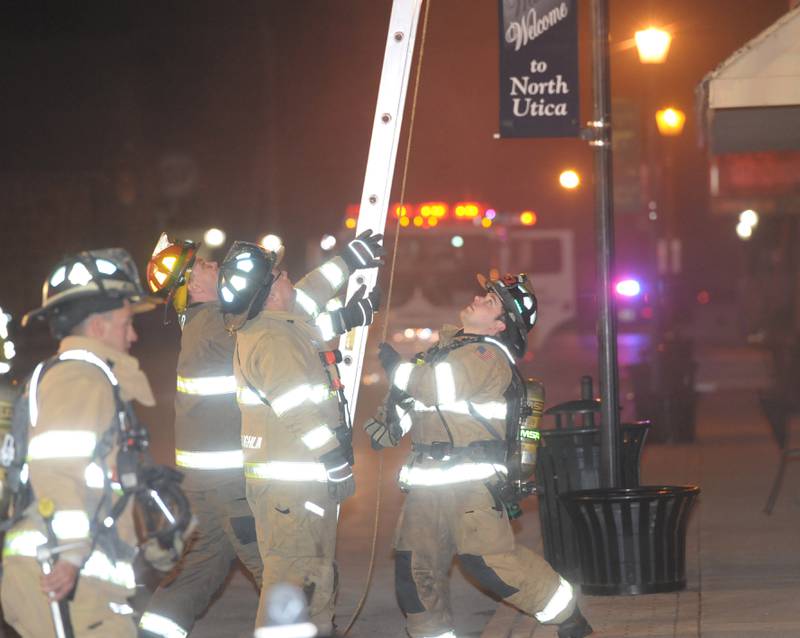 Firefighters (from left)  Neil Nadolski Peru fire, Brian Zeller Lasalle Fire,  Matt McLaughlin, Peru Fire and Justin Sullivan Peru fire, hoist a ladder outside Skoogs Pub & Grill on Sunday, May 10, 2015 downtown Utica.