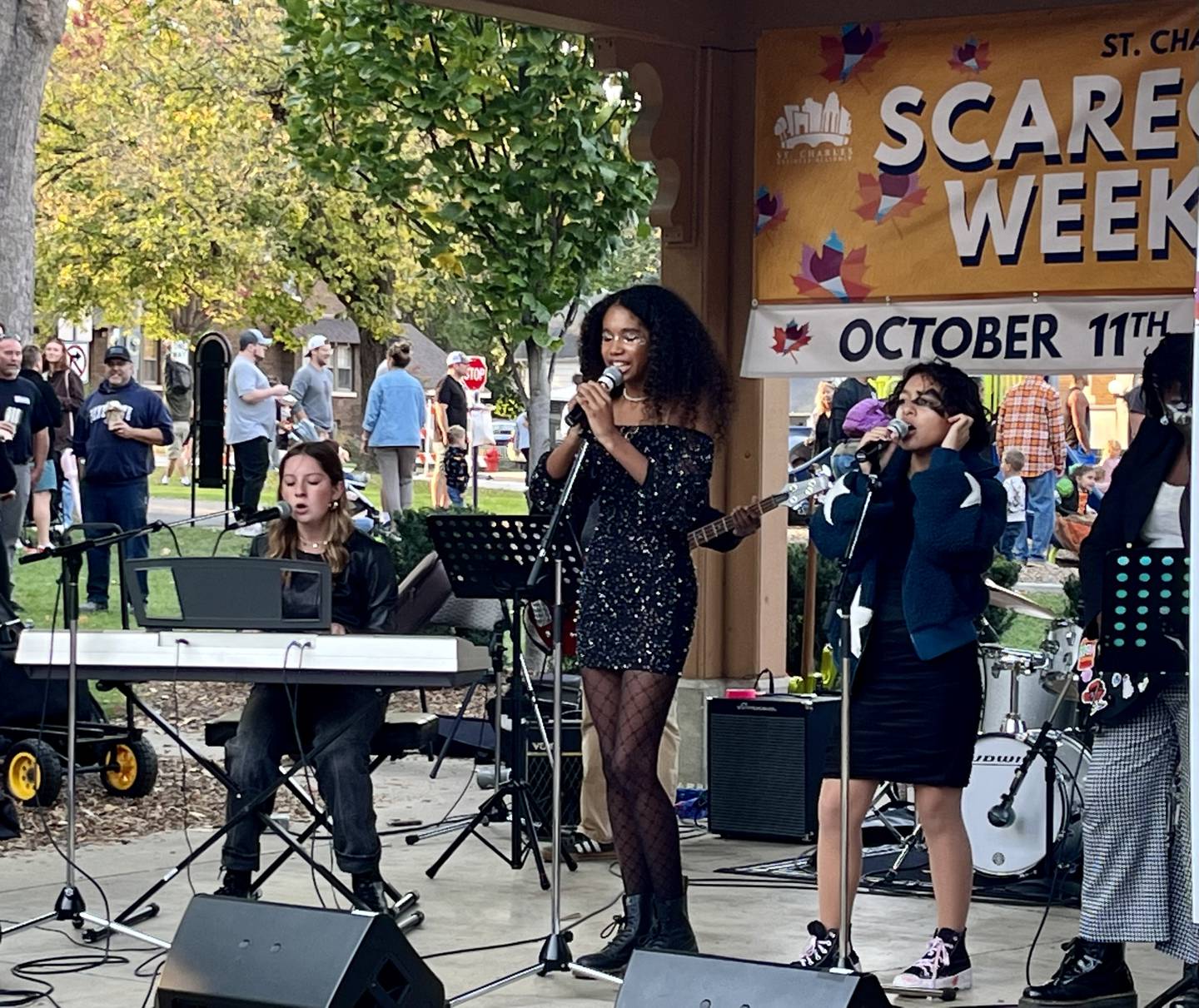 Teenage students of Hunt House Creative Art Center, Vivi Hancock (left) and Felicity Momoh-Bedwell (center), serenade the crowd at the 39th annual Scarecrow Fest in downtown St. Charles.