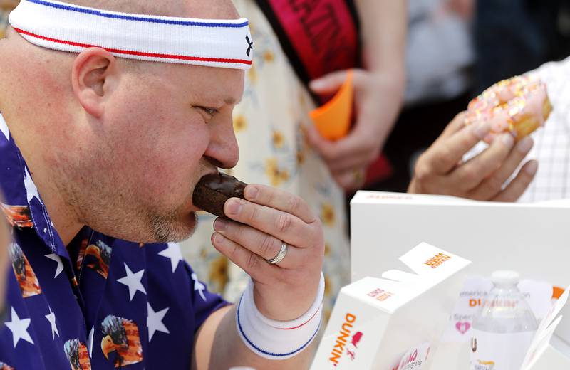 Donut eating contestant Matthew Ganek of the Huntley Police Department eats a donut while competing at Dunkin’ Donuts, in Huntley, during the Cop on a Rooftop fundraiser to raise awareness for Special Olympics Illinois and the Law Enforcement Torch Run to benefit Special Olympics on Friday, May 19. 2023.