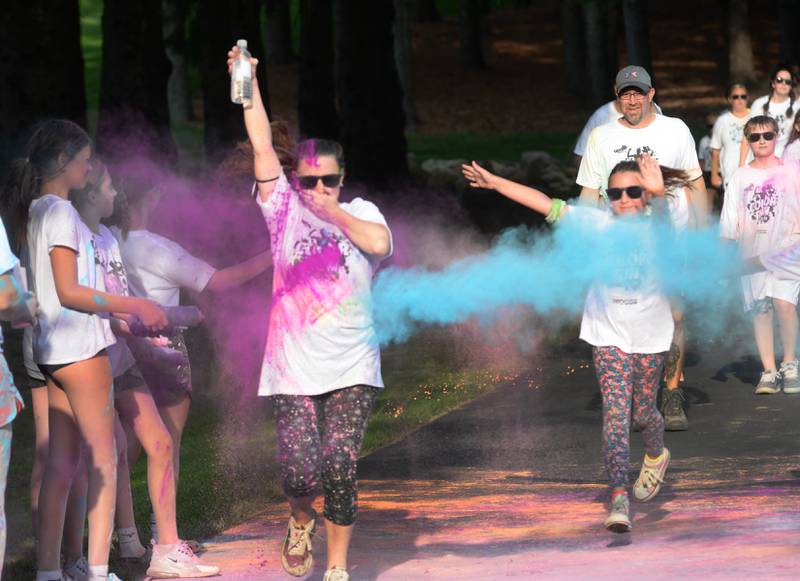 People run and walk  through a powder station at the Oregon Park District's Color Run on Tuesday, July 22, 2025 at Oregon Park West.