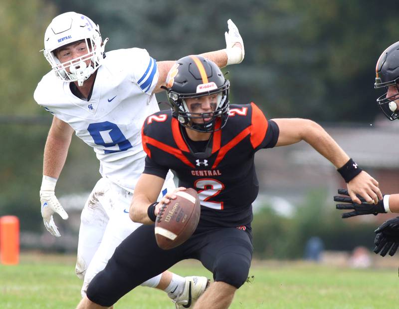 Crystal Lake Central’s quarterback Jason Penza escapes Zachary Adamo of Burlington Central in varsity football at Crystal Lake Saturday.