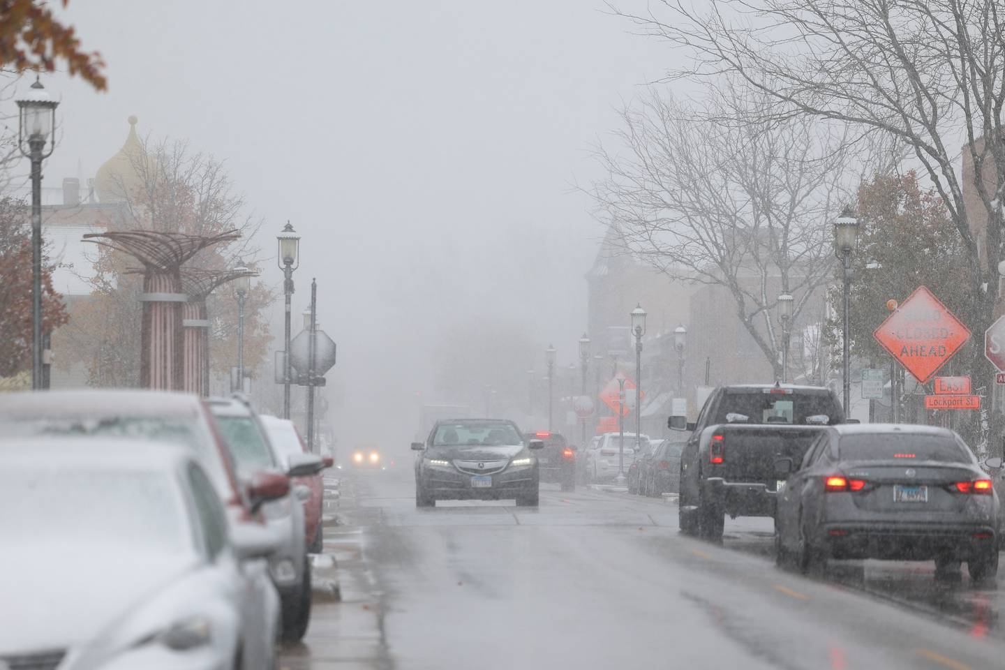 Snow falls as traffic moves along West Lockport Street in downtown Plainfield on Thursday, Nov. 21, 2024.