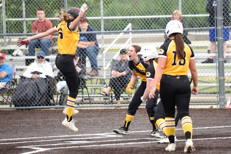 From left, Herscher's Lexi Crawford leaps as she approaches home plate and is greeted by Tigers teammates Keira Ahramovich, Reese Hartman and Chloe Kinkade greet her after Crawford's three-run triple and run on an error during a Class 2A Manteno Regional quarterfinal against Peotone at Herscher Monday, May 18, 2026.
