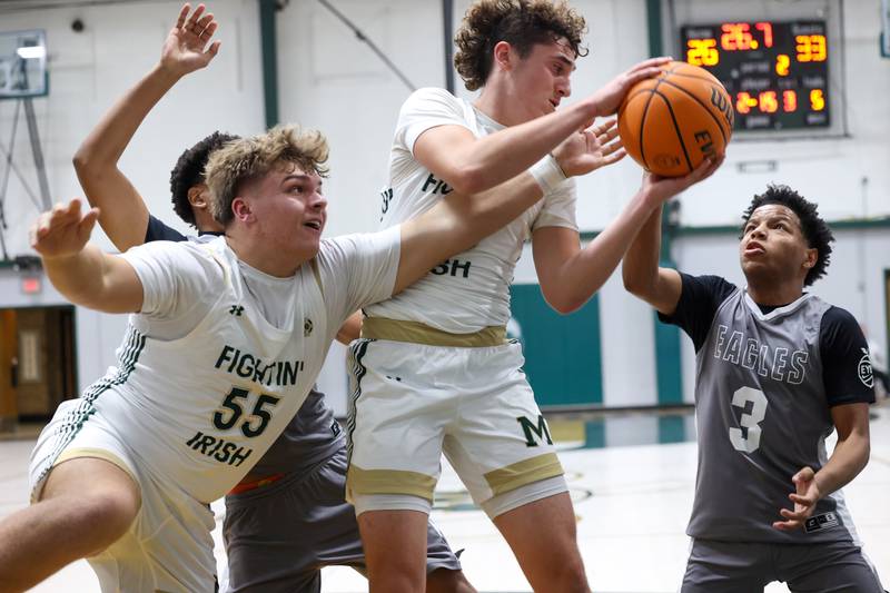 Bishop McNamara's Ian Irps, left, and Karter Krutsinger reach for a rebound during the Fightin' Irish's 70-51 loss to Hope Academy on Tuesday, Dec. 9, 2025
