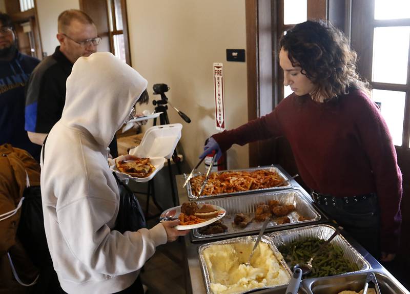 Natalie Jedynak of Warp Corps,, serves food during a free pre-Thanksgiving luncheon on Wednesday, Nov. 22, 2023, at the Woodstock train depot. This is the second year the meal that was provided through efforts of Warp Corps, MBI Cares, Isabel’s Family Restaurant, and Napoli’s Pizza, all located in Woodstock