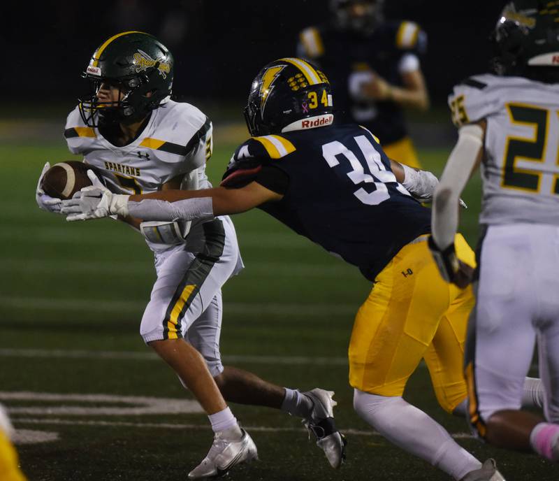Glenbrook North's Reese Marquez (3) during carries the ball after making a catch in front of Glenbrook South’s Nate Canning (34) Friday’s game in Glenview.