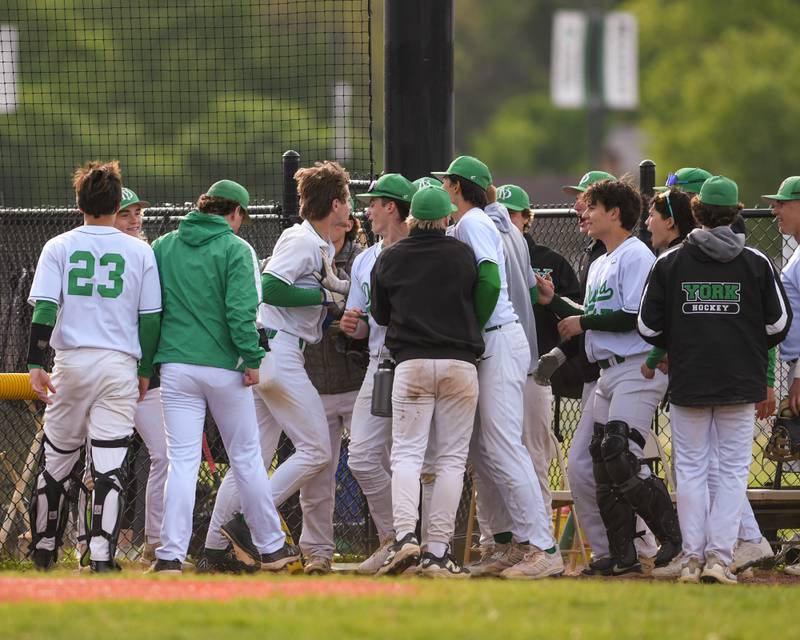 York's Josh Fleming, center, gets congratulated by his teammates after hitting a two-run homer during the game on Monday May 19, 2025, while taking on Downers Grove North held at York High School in Elmhurst.