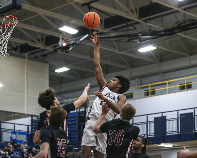 Oswego East's Dshaun Bolden (24) puts up a shot over the defense during their basketball game between Plainfield North at Oswego East Friday, Dec 5, 2025 in Oswego.