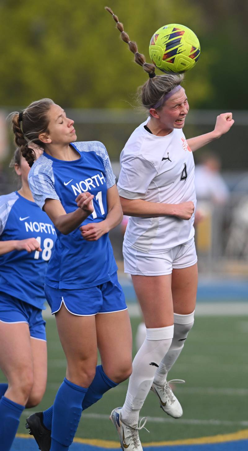 Wheaton Warrenville South’s Ashley Alman, right, leaps for a header to direct the ball past Wheaton North’s Emily Offutt during Thursday’s girls soccer match at Wheaton North.