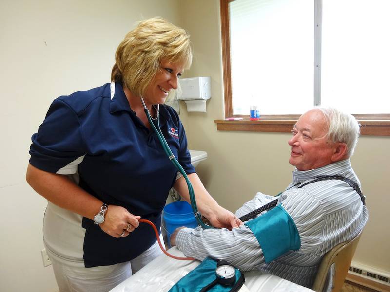 Dawn Kimpflin (left) an EMT with the Shabbona Fire Department, checks the blood pressure of Alfred Aspengren of Shabbona during the open house wellness event of the United Neighborhood Center in Shabbona on Saturday, Sept. 20.