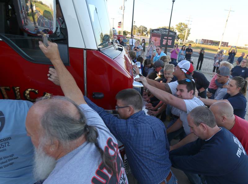 Utica firefighters, push in a new Pierce Heavy Duty Rescue Truck into the bay at the Utica Fire Station on Thursday, Sept. 14, 2023. It's a tradition for the Utica Fire Department to push in a new fire truck into the bay. The $706,000.00 truck will replace a 28 year old rescue truck. The new vehicle will have equipment to handle water rescue, industrial accidents and grain bin emergencies. The department hopes to have it in operation on Columbus Day weekend.