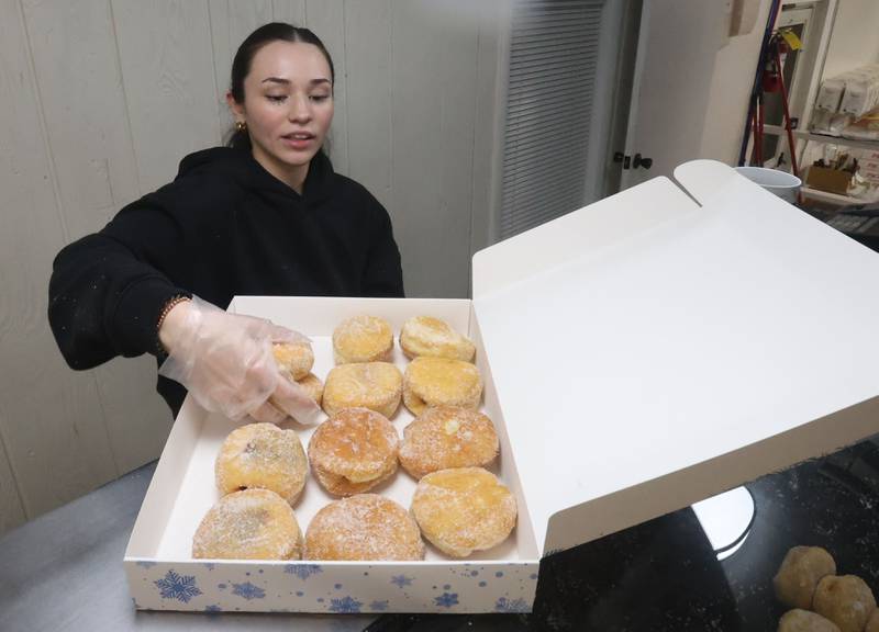 Shechinah Ridley places Paczki's inside a box on Tuesday, Feb. 17, 2026, in Spring Valley. Paczkis are rich, deep-fried Polish doughnuts traditionally filled with fruit preserves such as plum or rose hip jam and topped with powdered sugar or glaze. The pastries date back to the 1700s, when Polish bakers used up sugars, jellies and other ingredients to create the treats ahead of Lent.