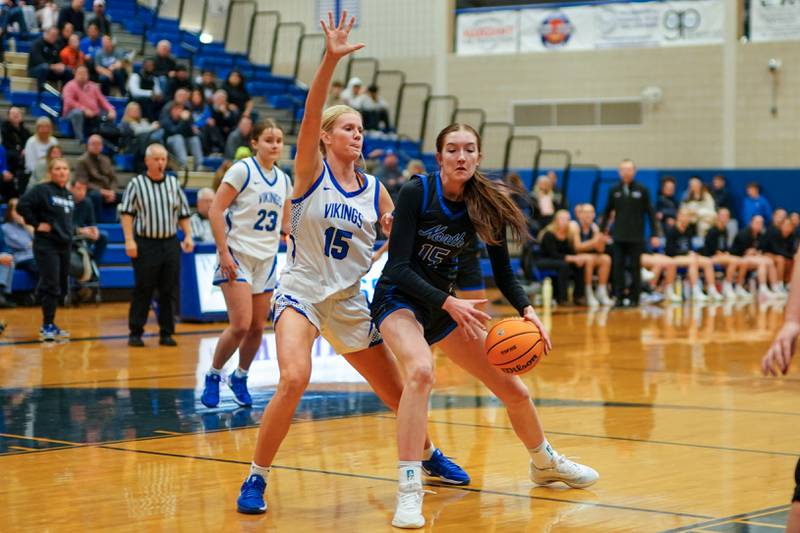 St. Charles North's Bronwyn How (right) plays the ball in the post against Geneva’s Emma Peterson during a game at Geneva High School on Thursday, Dec. 4, 2025.