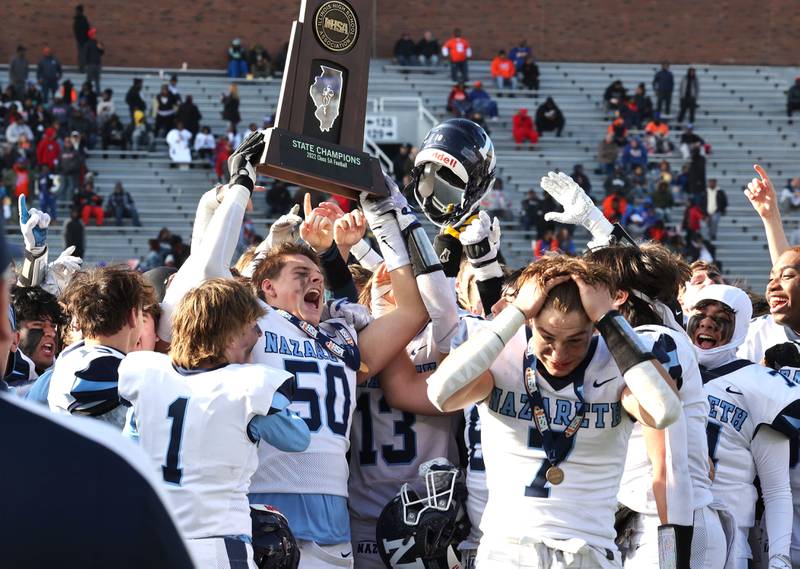 Nazareth's William Beargie and his teammates hoist the trophy after their IHSA Class 5A state championship win over Peoria Saturday, Nov. 26, 2022, in Memorial Stadium at the University of Illinois in Champaign.