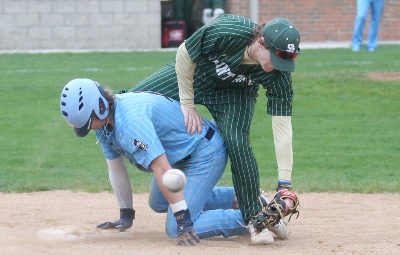 The ball gets away from St. Bede's Luke Tunnell as Marquette's Jackson Higgins dives back into the bag at first base at Masinelli Field on Thursday, April 18, 2024 in Ottawa.