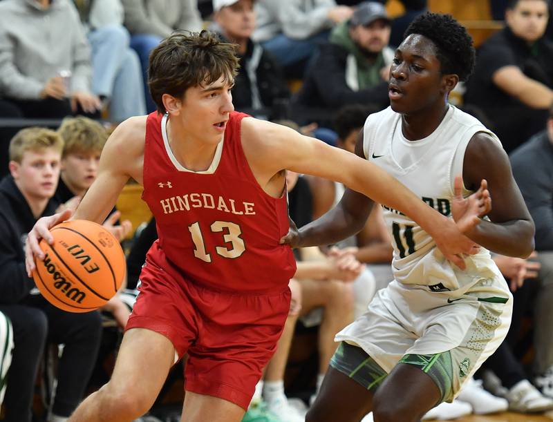 Hinsdale Central’s Michael Howell (13) drives as Glenbard West’s Teyion Oriental defends during a game on January 31, 2025 at Glenbard West High School in Glen Ellyn.