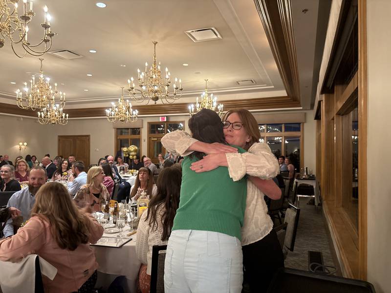 McHenry County Educator of the Year winner Dawn Wiginton, left, gets a hug from colleague Denise Manthey at the McHenry County Educator of the Year ceremony in Lake in the Hills, Saturday, May 9, 2026.