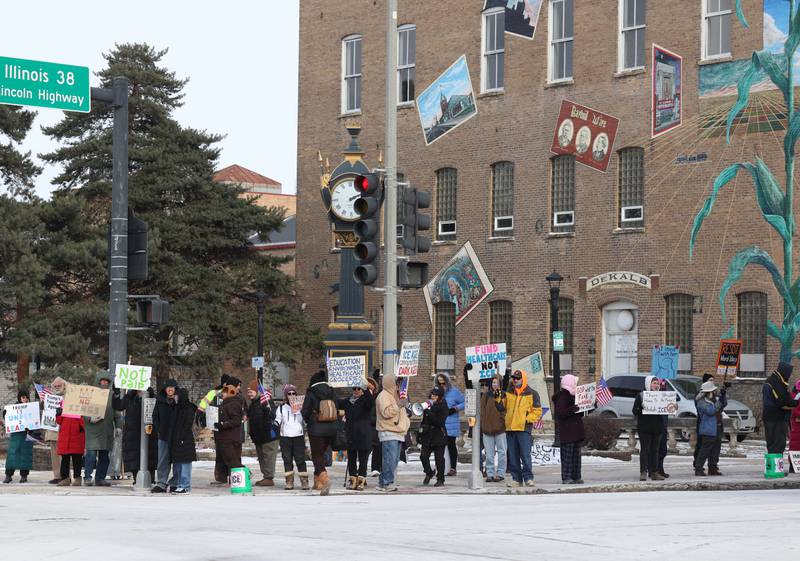 Protesters gather Tuesday, Jan. 20, 2026, at Memorial Park on the corner of First Street and Lincoln Highway in DeKalb as part of a national Free America Walkout. The group is protesting what they perceive as an escalating fascist threat under President Donald Trump and his administration.