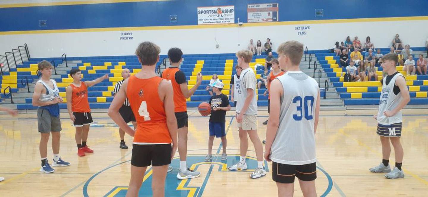 Jackson Werderitch, who was struck by a car a month ago, tosses up the ball for the jump ball at the McHenry vs. Johnsburg varsity game on Saturday. The day of hoops went to benefit the Werderitch family.