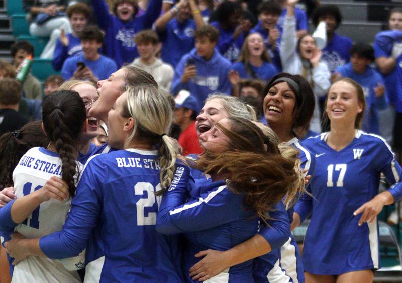 Woodstock’s coaches and players get excited after a win in varsity volleyball at Woodstock North Monday night.