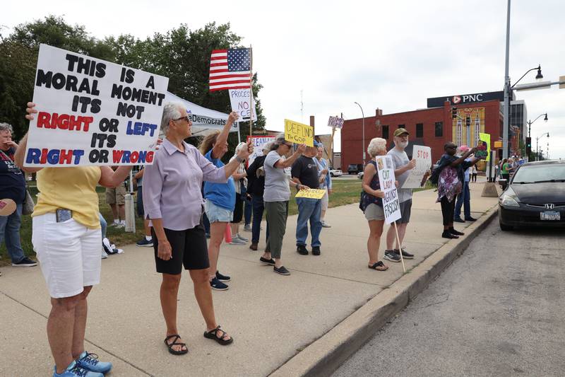 Protesters hold signs along East Court Street during a "Good Trouble Lives On" rally held in Kankakee as part of a national day of peaceful protests on Thursday, July 17, 2025.