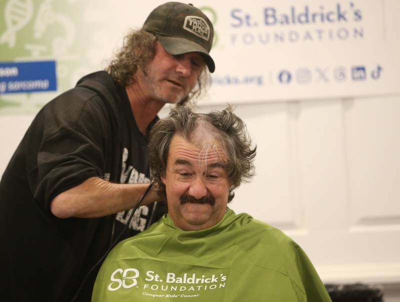 Troy Edwards owner of Troy's Place in Arlington, takes a "first swipe" on the hair of Frank Ponder during the 18th annual Illinois Valley Emergency Services St. Baldrick's event on Sunday, March 23, 2025 at Senicas Oak Ridge in La Salle.