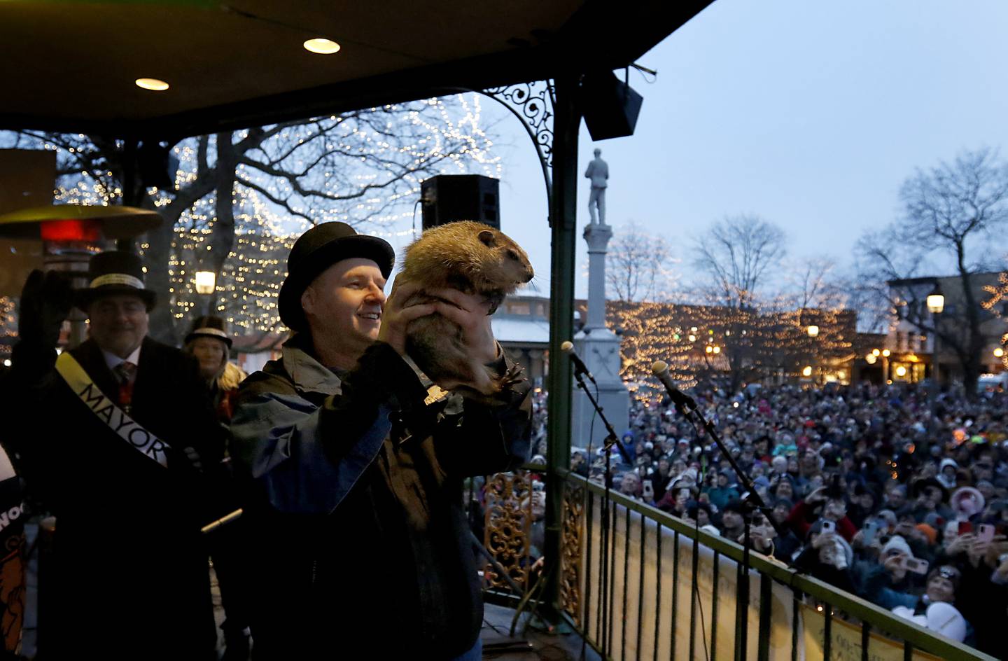 Woodstock Willie is held by handler Mark Szafran as Willie looks to see if he can see his shadow on Sunday, Feb. 2, 2025, during the annual Groundhog Day Prognostication in the Woodstock Square.