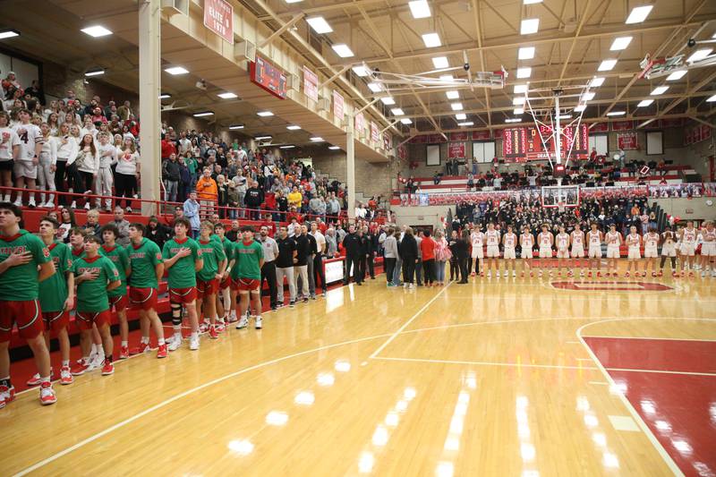 Members of the L-P and Ottawa boys basketball teams stand for the National Anthem before the 250th meeting between the two teams in Kingman Gymnasium on Friday, Feb. 10, 2023 at Ottawa High School.