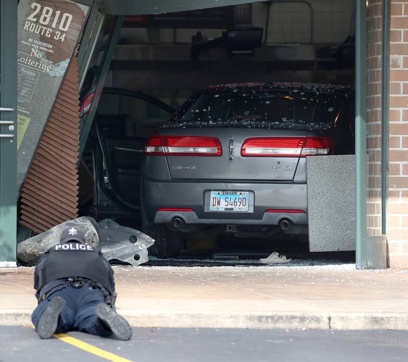 An Oswego Police officer photographs the scene Wednesday, July 30, 2025, where a car crashed through the front entrance of the Portillo’s at 2810 U.S. Route 34 in Oswego injuring 12.