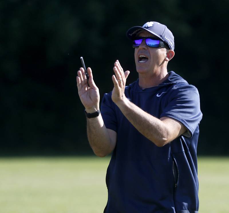Cary-Grove Coach Brad Seaburg explains their play calling to players during summer football practice Thursday, June 30, 2022, at Cary-Grove High School in Cary.