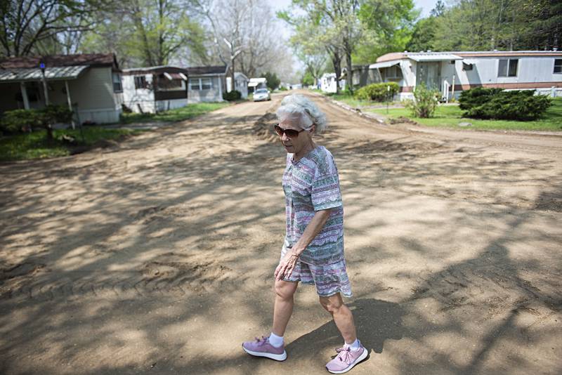 Cynthia Mammosser walks near her home at Riverside Estate in Rock Falls Tuesday, May 10, 2022. New owners have taken over and are moving forward to renovated the park starting with repaving the roads.