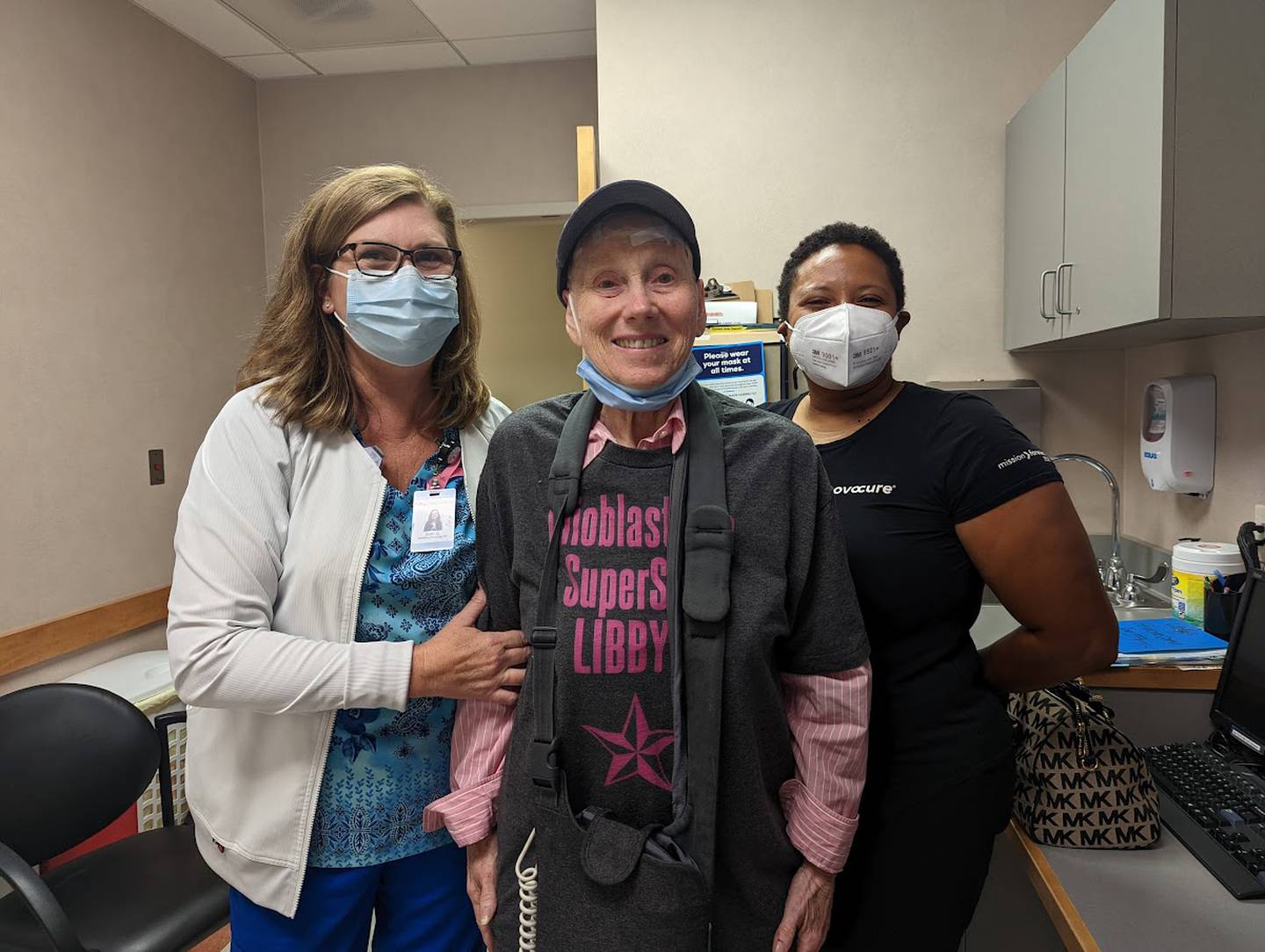 Libby Hall, 75, of Joliet, (center) is seen on Friday, Sept. 16, 2022, at Joliet Oncology-Hematology Associates. Hall was diagnosed with glioblastoma multiform, an aggressive brain cancer, in 2020 and is currently wearing a device called Optune, which delivers an electrical field into the cancer cells in her brain. Hall is pictured with JOHA radiation oncology nurse Joan Quaresima (left) and La Keysha James, a device support specialist with Novocure, the company that makes the device.