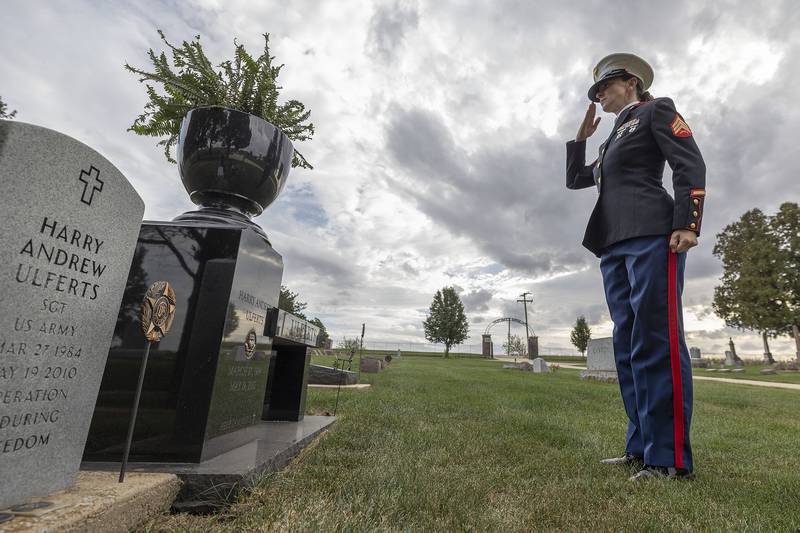 Elise Ulferts-Hume salutes her brother’s grave at Palmyra Cemetery Tuesday, Oct, 7, 2025. Ulferts joined the Marines to honor her Army veteran brother, Harry Andrew Ulferts, who died in a car accident in 2010.