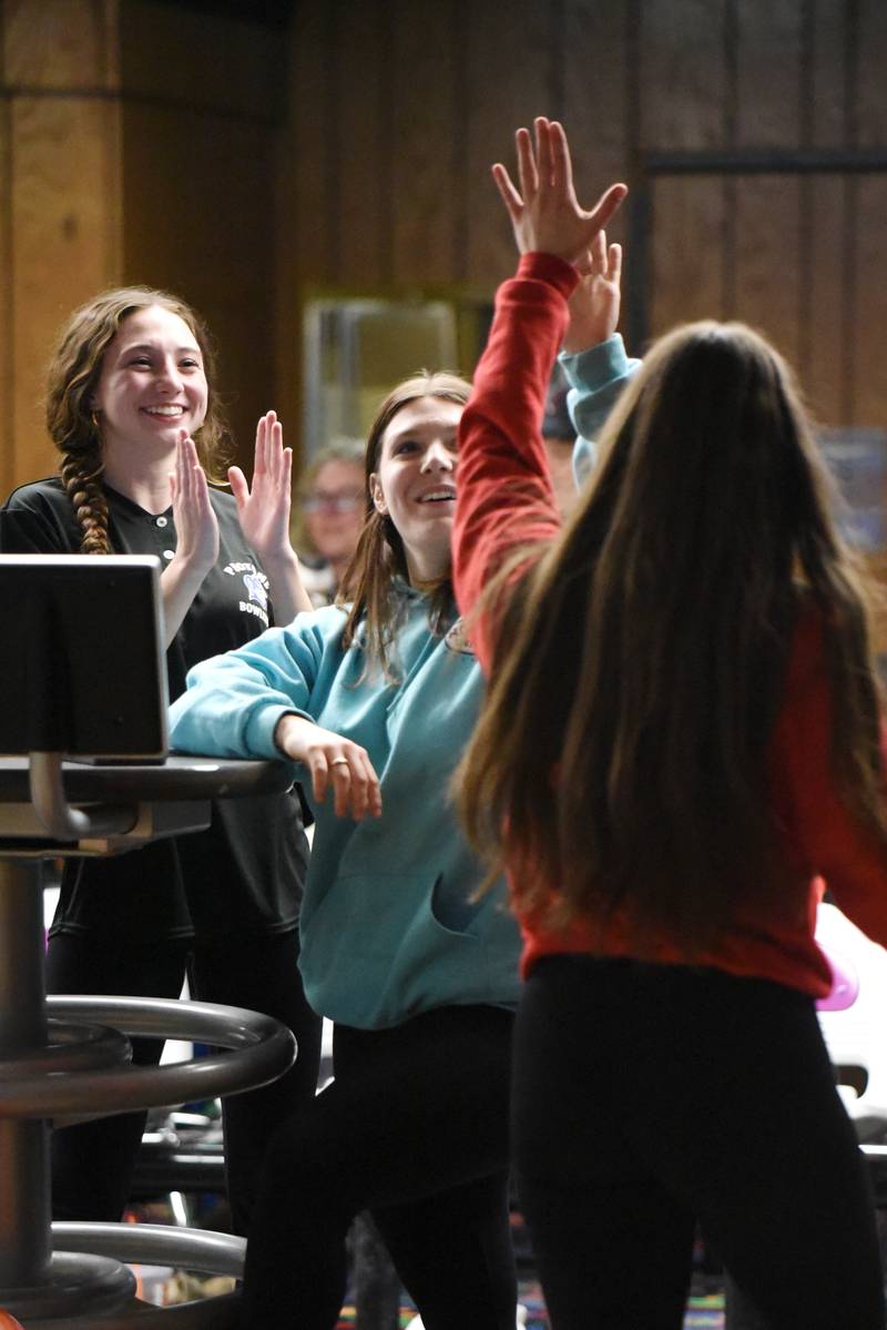 Peotone's Emily Brown, center, high fives teammate Addison Daoud, right, as Kate Cuthbertson applauds Daoud during the All-City girls bowling meet at Brookmont Bowling Center in Kankakee Wednesday, Feb. 5, 2025.
