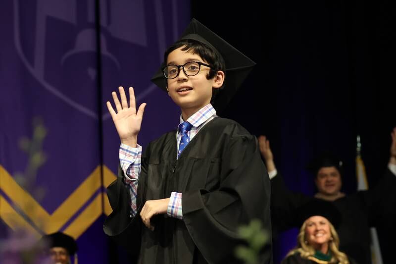Benyamin Bamburc waves to the cheering crowd after receiving his Associate in Arts Degree at the Joliet Junior College Commencement Ceremony on Friday, May 19, 2023, in Joliet.