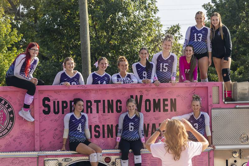 The DHS JV volleyball team poses for pictures atop the Pink Heals firetruck Thursday, Oct. 2, 2025, outside of the high school. In recognition of Breast Cancer Awareness Month, the teams raised money through donations and sales to donate $500 to Pink Heals and also a donation to a community member battling cancer.