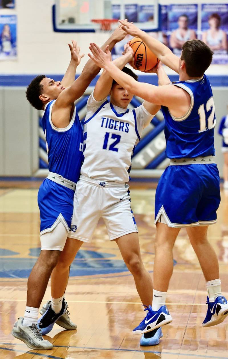 Princeton's Daniel Barnes gets smothered by Newman's Tyson Williams (1) and Evan Bushman Saturday night at Prouty Gym.